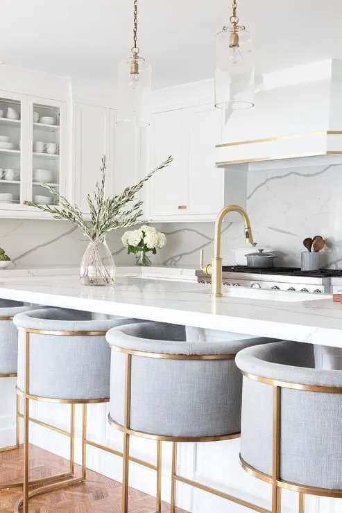 Bright kitchen with gold fixtures and bar stools